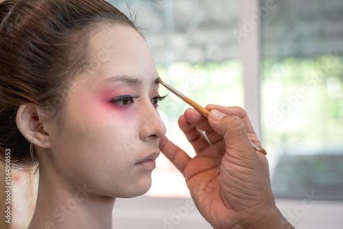Close up make up artist doing geisha make up for maiko woman