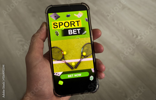Man betting on sports, holding smart phone with working online betting mobile application