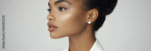 Female model in white blazer for fashion blog header, 3:1 banner image with clean gray background and copy space on the right, minimalist beauty concept in soft lighting