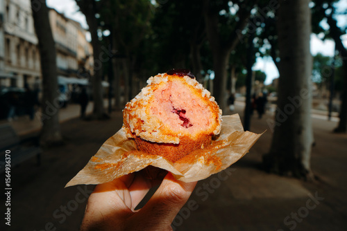 man eating a muffin filled with strawberry jam