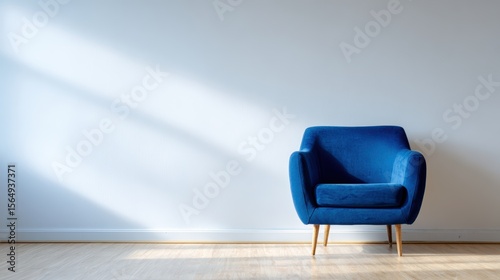 Cozy blue armchair positioned against a minimalist wall, showcasing natural light streaming in, creating a serene and inviting atmosphere