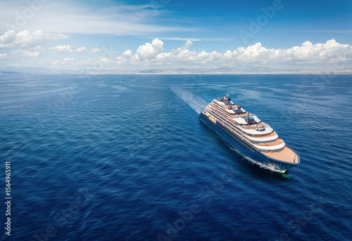 Fototapeta Naklejka Na Ścianę i Meble -  Aerial front view of a modern luxury cruise ship or yacht sailing with speed over calm ocean with copy space