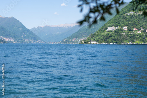 The stunning Lake Como landscape, with its beautiful green mountains and clear blue water.