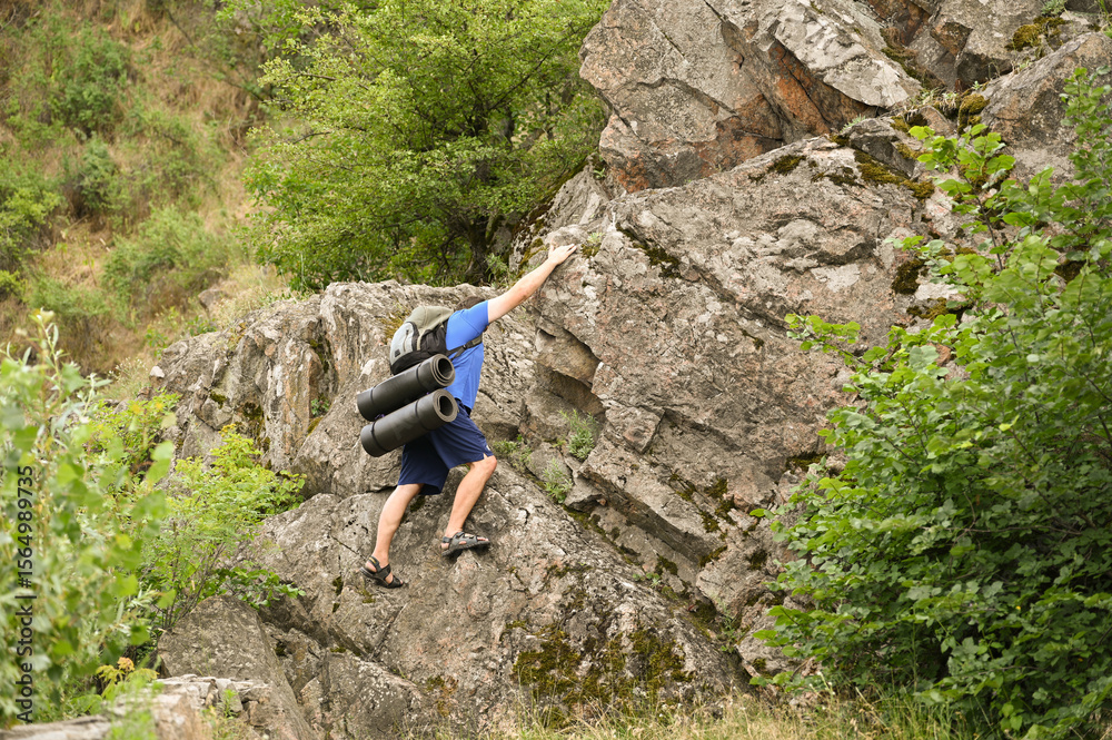 Obraz premium man in sports suit with backpack doing active sports on mountain