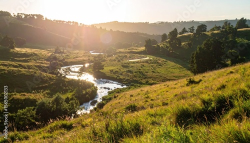 Sunlit valley A river winds through grassy hills, dappled by the setting sun's warmth
