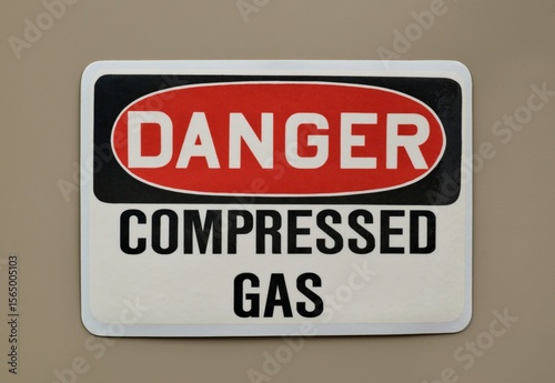 Danger Compressed Gas safety sign warning notice on wall industrial occupation.
