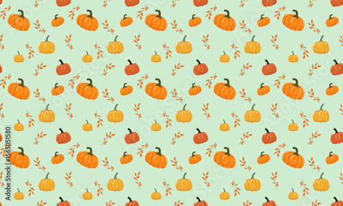 Vector seamless autumn pattern with pumpkins and twigs with leaves on a green background.