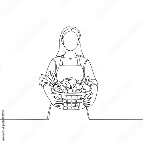 Woman holding a basket of fresh vegetables in apron  