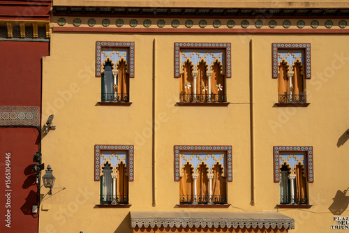  A vibrant traditional Andalusian courtyard in Cordoba, overflowing with potted flowers and lush greenery, set against whitewashed walls and historic architectural details under natural light.