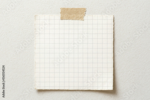 Blank vintage sheet of aged grid paper on textured wall, this rustic empty note mockup has brown craft tape