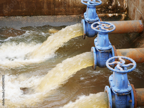Schilderij op canvas Industrial drainage system with five blue pipes discharging water into a reservoir
