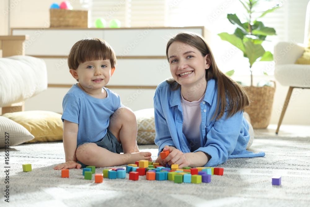 Fototapeta premium Mother and son playing with colorful cubes at home