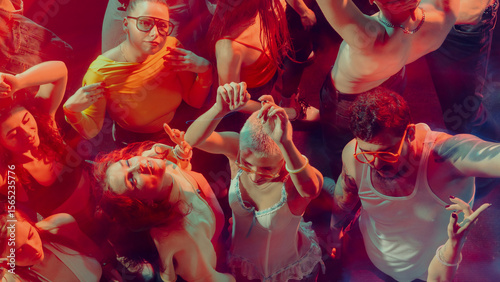 Fotografía A vibrant crowd dancing energetically under colorful lights in a club atmosphere