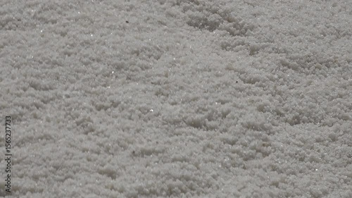 Abstract close-up shot of salt falling down on pile (as it drops from conveyor belt), in Chott El Djerid, agriculture and economy in Tunisia

