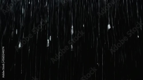 A looping heavy rain animation over a black background with isolated raindrops, ideal for visual effects and compositing.