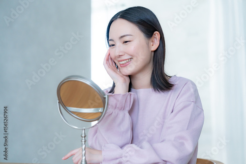 部屋で鏡を見る女性