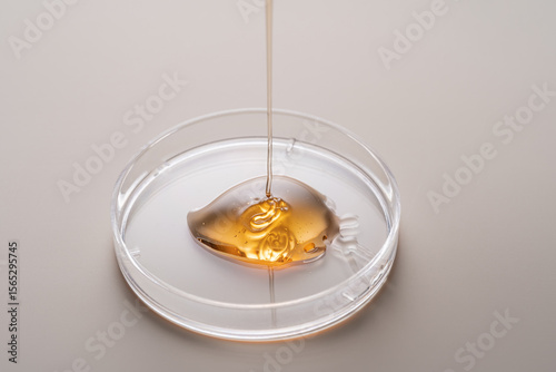 Golden liquid in petri dish for cosmetic formulation