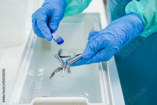 Konstfotografi Close-up of gloved hands meticulously scrubbing surgical instruments with a smal
