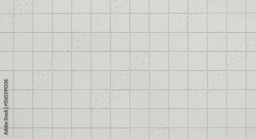 Wall covered in small uniform lightcolored square ceramic tiles with thin light grey grout lines