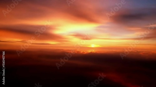 Dramatic sunset over clouds with vibrant red and orange hues  