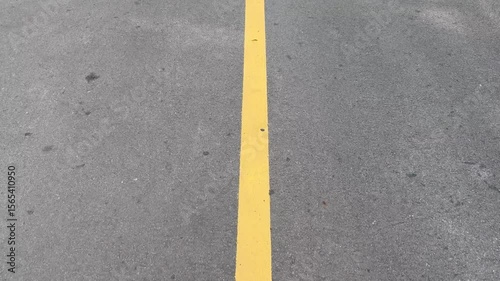 Footage of a walk along a yellow lane divider.