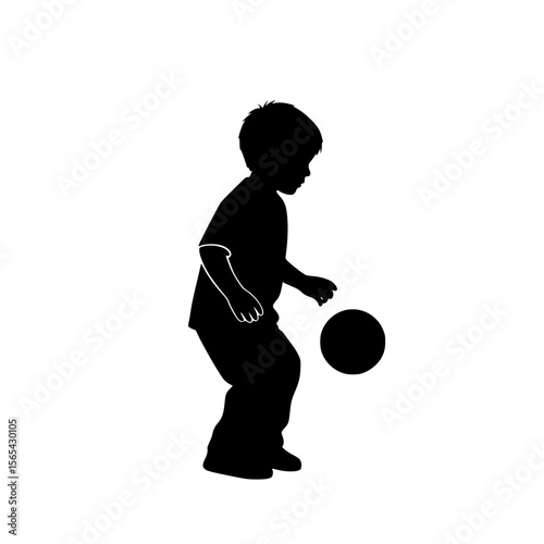 Silhouette of a young boy playing soccer with a ball