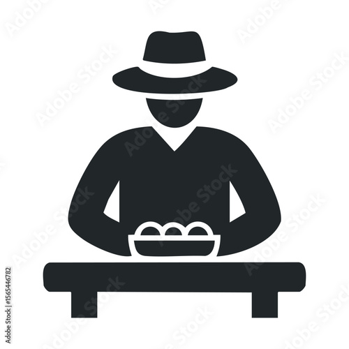 Silhouette of mysterious figure in hat at table