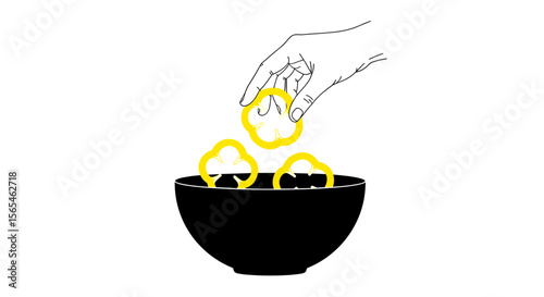 Hand placing yellow bell pepper rings into a black bowl on white background, healthy ingredient preparation concept
