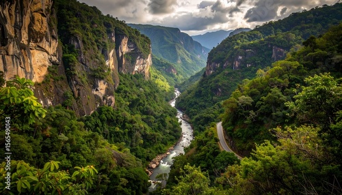 A winding river flows through a lush green valley with towering rock cliffsides