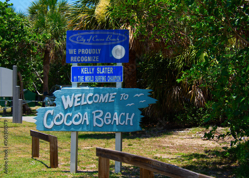 Welcome to City of Cocoa Beach Florida road sign with lush green vegetation in the background on a sunny morning.
