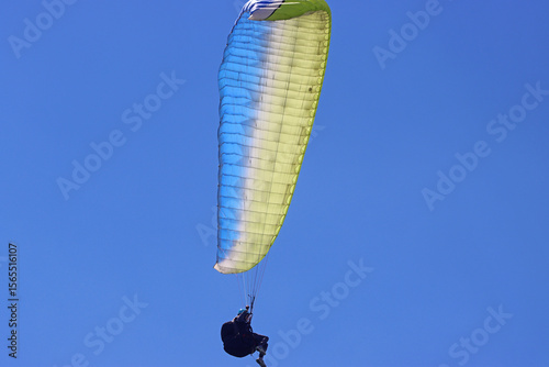 Paraglider flying in a blue sky	