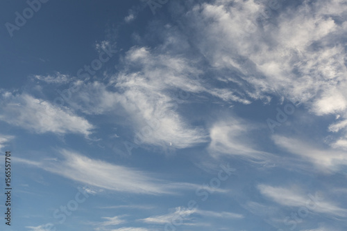Beautiful wispy clouds drift across a bright blue sky during a sunny afternoon