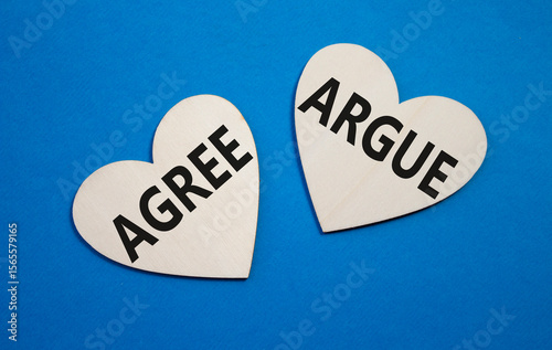 Agree or Argue symbol. Concept word Agree or Argue on wooden hearts. Beautiful blue background. Business and Agree or Argue concept. Copy space