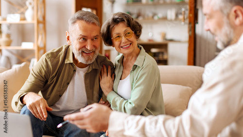 Male realtor consulting senior couple buyers showing project on laptop, man and woman clients buy house from agency. Rental concept