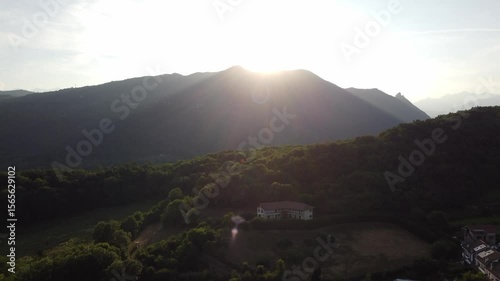 Aerial sunset view of Avigliana, Italy, Piedmont , Turin,Italy A beautiful town with a medieval castle and red-roofed houses, surrounded by the green hills of Susa and trees on a sunny day.