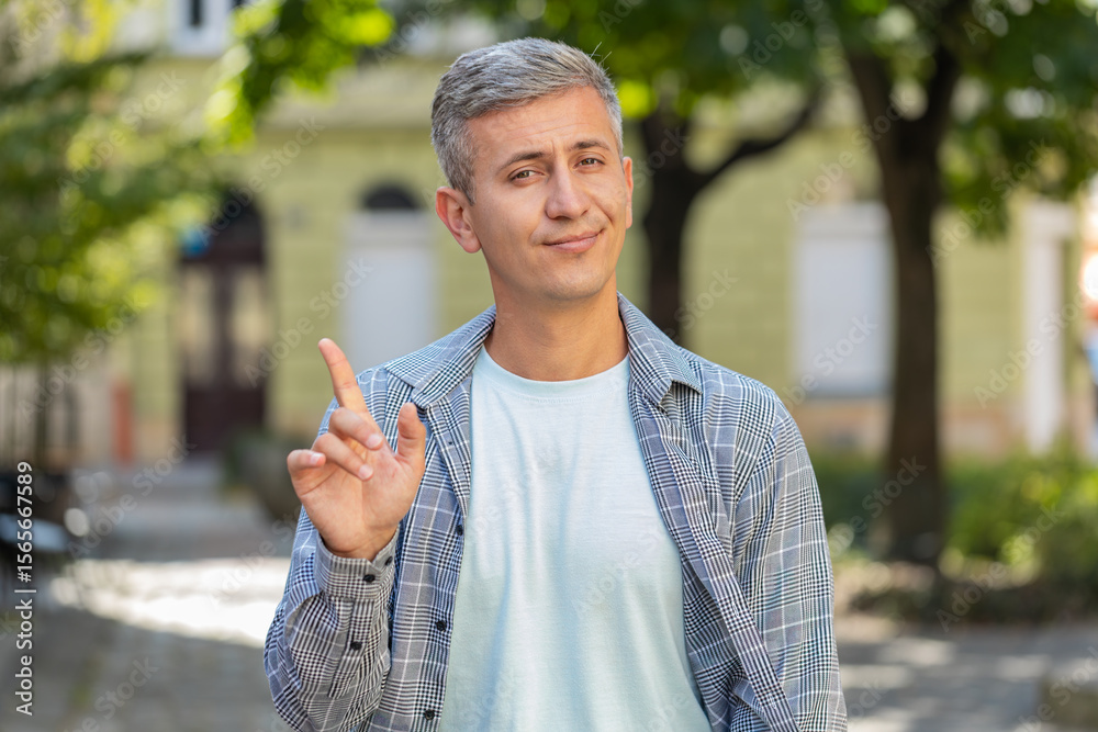 Fototapeta premium Displeased upset middle-aged man reacting to unpleasant awful idea, dissatisfied with bad quality, wave hand, shake head No, dismiss idea, don't like proposal. Mature adult guy traveler on city street