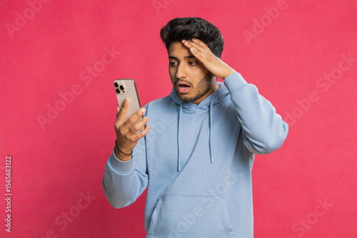 Obraz na plátně Upset sad Indian man use smartphone typing browsing, play game, loses, surprised by sudden lottery results bad fortune loss fail unlucky news