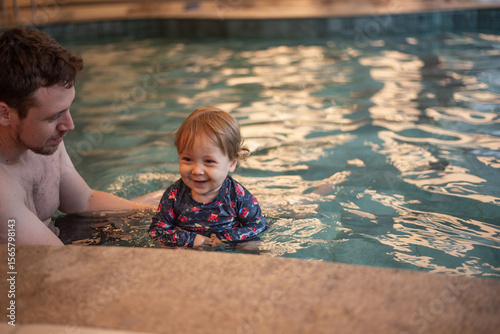 Father and baby son having fun in a kiddie pool