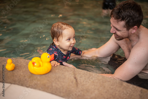 Father and baby son having fun in a kiddie pool