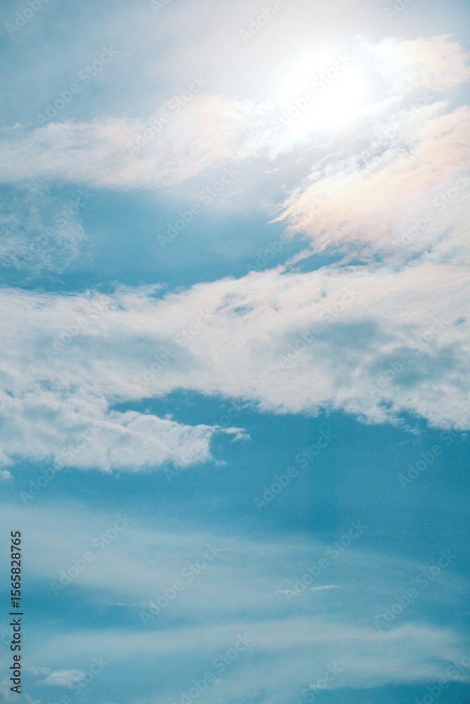 Obraz premium Bright blue sky with white clouds and glowing sun for background, texture, nature and design concepts, 눈부신 태양과 흰 구름의 파란 하늘 배경, 텍스처, 자연, 디자인 콘셉트 활용