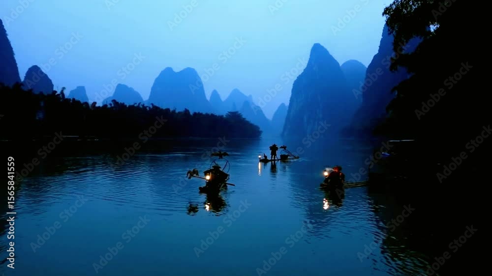 Fishermen navigate the li river on bamboo rafts at dusk