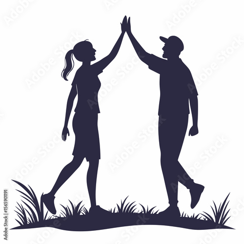 Silhouettes of a man and woman giving each other a high five in the grass