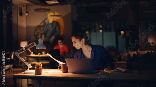 Overloaded entrepreneur reading papers at laptop workplace. Tired businesswoman 