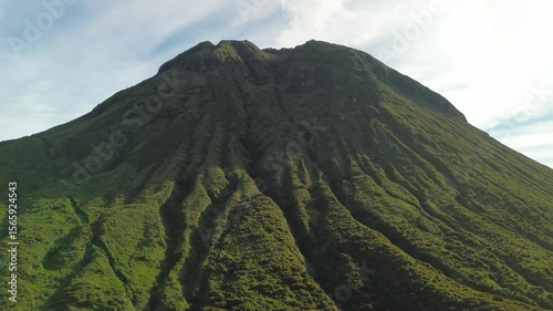 Wallpaper Mural The camera advances toward Mount Apo, exposing radial green gullies carved down its massive cone while soft morning light and wispy summit steam rise into a pale blue sky. Torontodigital.ca