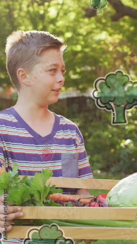 Animation of fruit and vegetables icons over happy caucasian siblings with box of vegetables