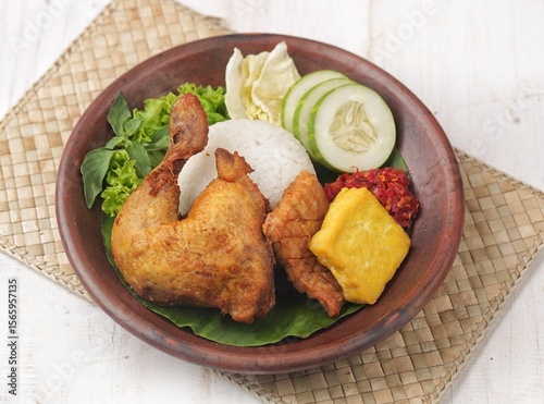 Pecel ayam or penyet ayam or fried chicken in Indonesia is the name of a typical Javanese food consisting of fried chicken and tomato sauce.