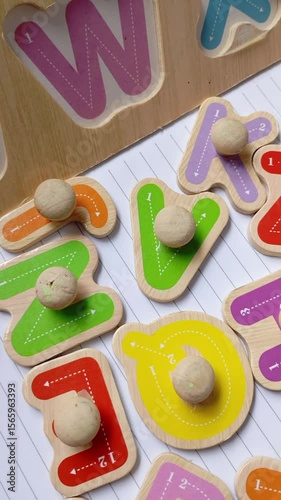 Children's wooden alphabet board. Colourful shape. Educational logic toys for kid's. Montessori method games for child development and logical education. White paper book background isolated