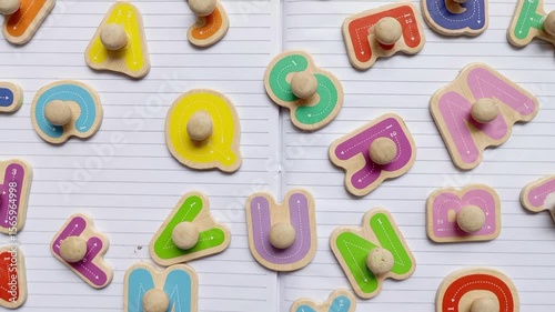Children's wooden alphabet board. Colourful shape. Educational logic toys for kid's. Montessori method games for child development and logical education. White paper book background isolated
