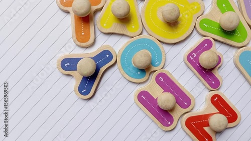 Children's wooden alphabet board. Colourful shape. Educational logic toys for kid's. Montessori method games for child development and logical education. White paper book background isolated