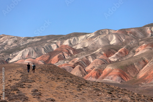 People walk through the beautiful red mountains. Khizi region. Azerbaijan.